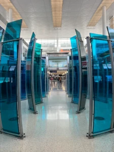 Paneles de vidrio azul turquesa en el pasillo del aeropuerto