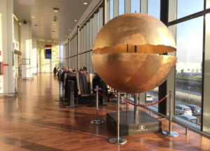 Escultura esférica dorada en el Aeropuerto de Bérgamo