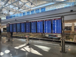 Múltiples pantallas de llegadas en el aeropuerto con luz natural