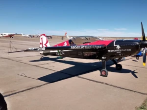 Avión acrobático negro y rojo en plataforma, Zapala
