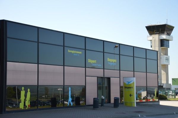Fachada del aeropuerto con indicaciones y torre de control