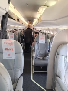 Pasillo central del avión con asientos y publicidad Jujuy