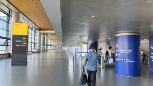 Interior del aeropuerto de Shanghái – Pudong: señalización y viajeros