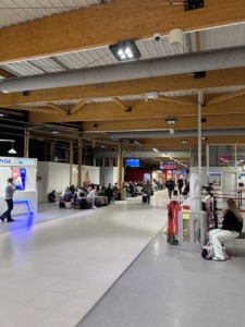 Interior del aeropuerto con personas esperando y techos altos