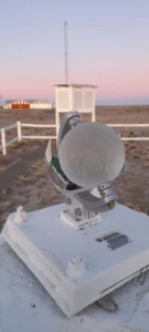 Esfera meteorológica escarchada y estación de medición al fondo