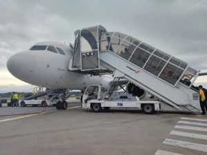 Avión blanco con escalera móvil en aeropuerto