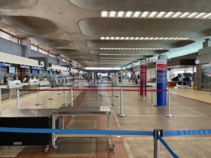 Interior del aeropuerto con mostradores de aerolíneas y señalización