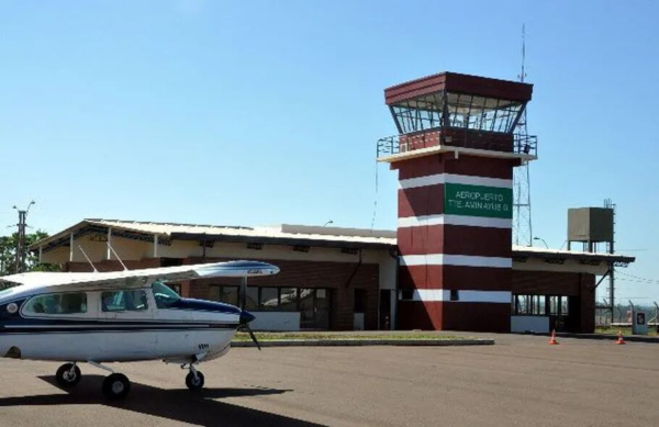 Avión estacionado frente a la torre de control del aeropuerto