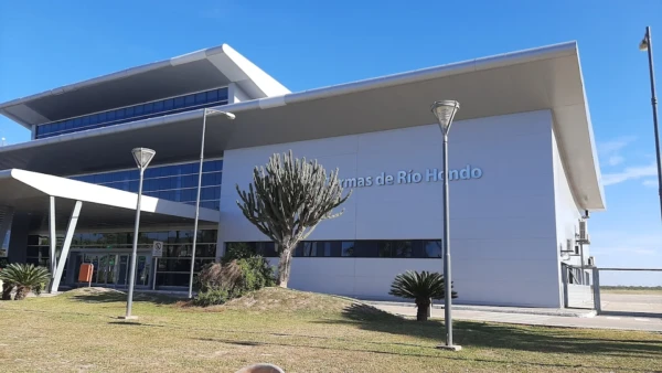 Fachada del aeropuerto con cactus y palmeras en primer plano