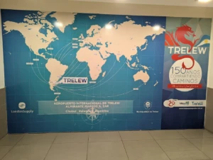 Mural con mapa mundial y logo de Trelew en aeropuerto