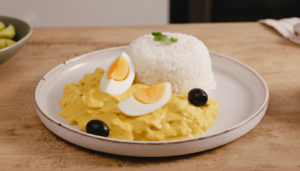 Delicioso ají de gallina peruano con arroz y aceitunas