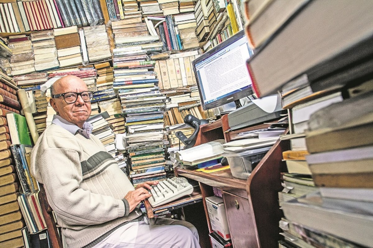 Escritor rodeado de libros y su teclado