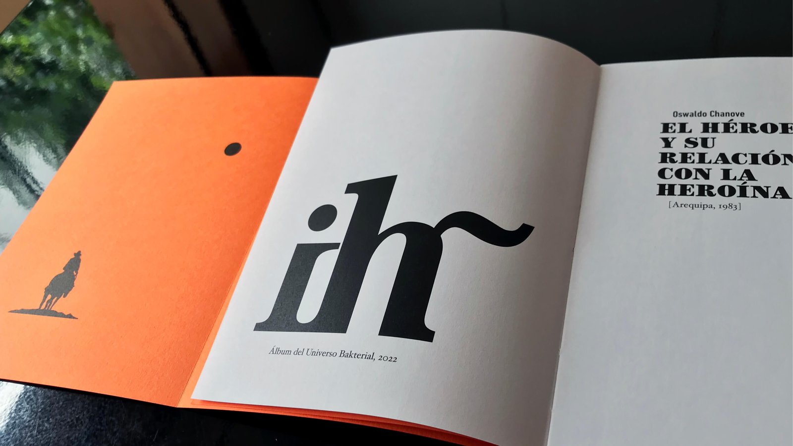 Libro abierto: tipografía, portada naranja, jinete solitario