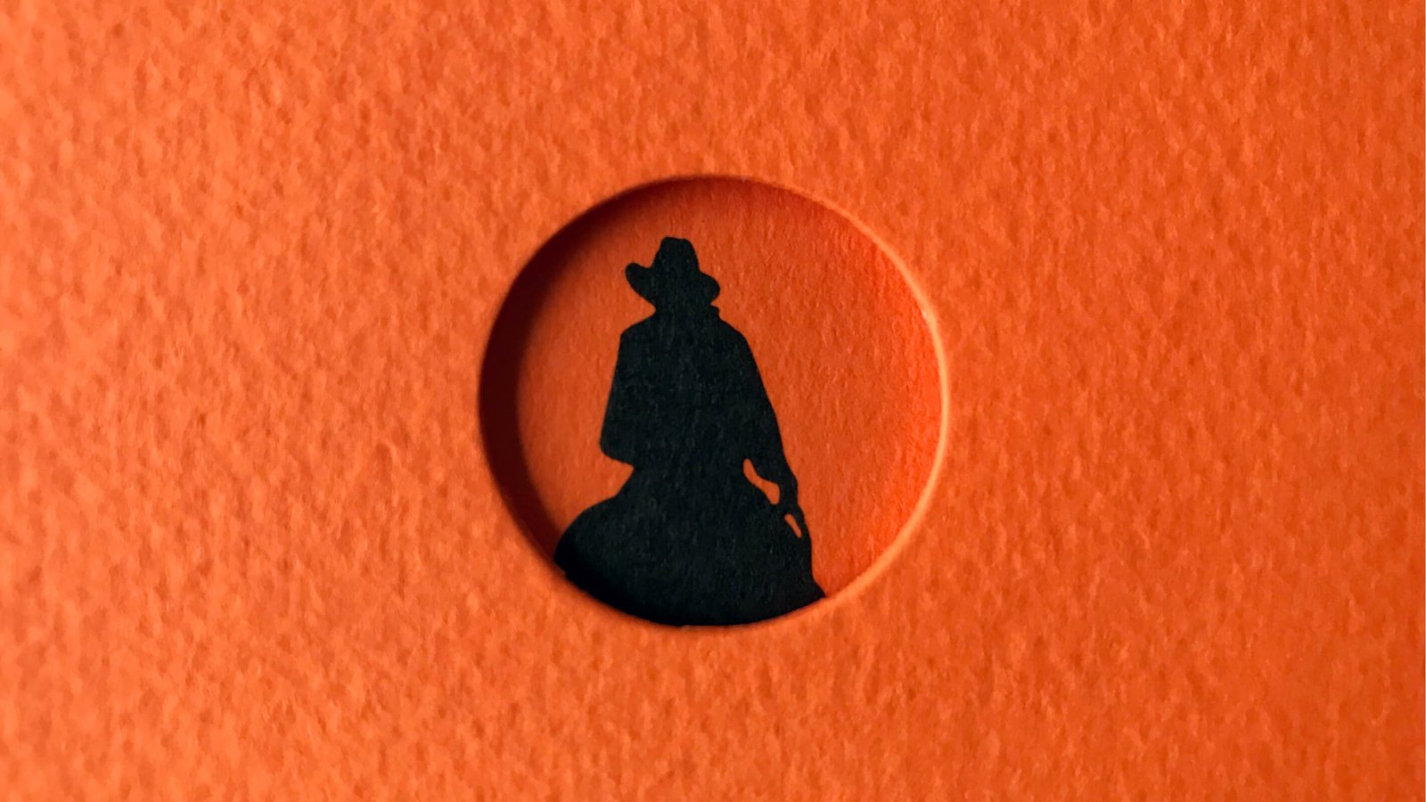 Silueta de vaquero en círculo anaranjado