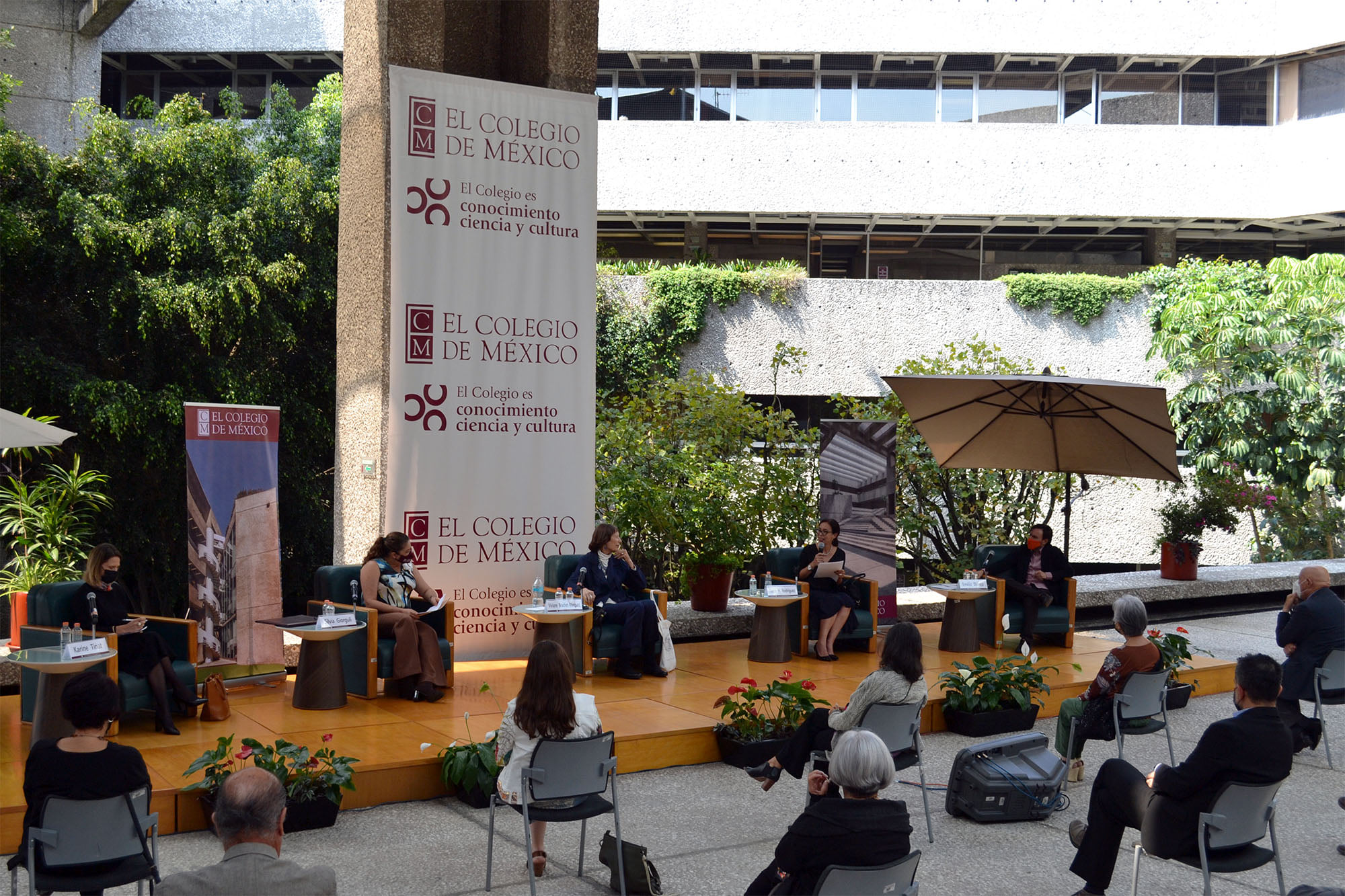 Panelistas y asistentes en evento al aire libre