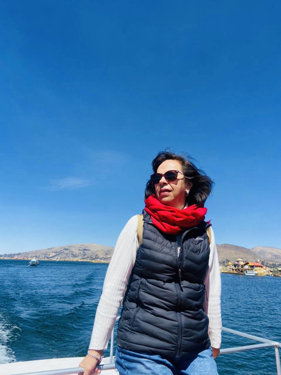 Viaje lacustre con estilo: chaleco y bufanda roja